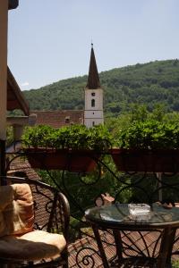 a table and chairs on a balcony with a church at Casa Ciortea Ana in Sibiel