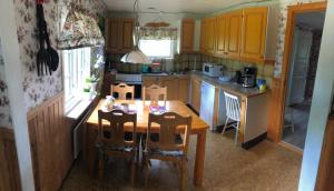 eine Küche mit einem Holztisch sowie einem Tisch und Stühlen in der Unterkunft Berget in Skillingaryd