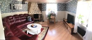 sala de estar con sofá de cuero y TV en Berget en Skillingaryd