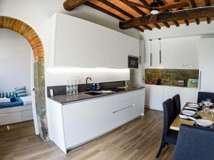 een keuken met witte kasten en een eettafel bij 7 Bridges Apartment in Loro Ciuffenna