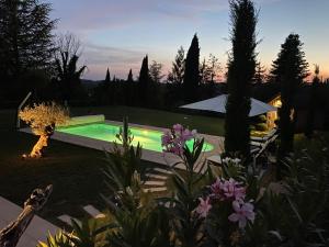 een zwembad in een tuin met bloemen bij Amity. Exclusive poolside garden apartment in Sarlat-la-Canéda