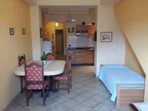 a kitchen and dining room with a table and a bed at Appartamenti Centrali Giardini Naxos in Giardini Naxos