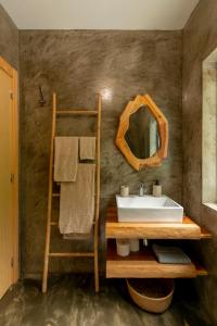 uma casa de banho com um lavatório e um espelho em Rosa Chá em Santo Amaro