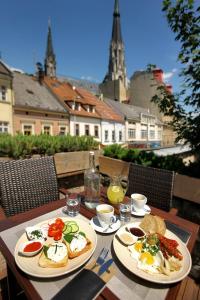 奧洛穆茨的住宿－Royal Pension，一张桌子,上面有两盘早餐食品