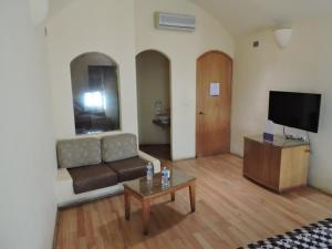 Motel Mykonos في بوبلا: غرفة معيشة مع أريكة وطاولة قهوة