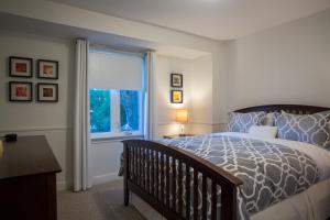 Un dormitorio con una cama grande y una ventana en By The Vines, en Niagara on the Lake