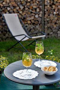 - deux verres de vin et un bol de nourriture sur une table dans l'établissement ALTESTANZEOSTANA, à Ostana
