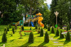 um parque infantil com escorrega num parque em Hotel Belvedere em Predeal