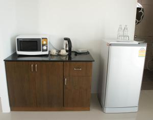 a microwave sitting on top of a counter next to a refrigerator at Chaba Place in Hua Hin