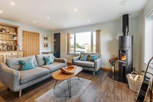 a living room with a couch and a fireplace at Skye Lodge Dunvegan Skye in Dunvegan