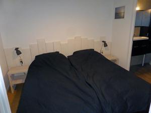 a bed with a wooden headboard in a bedroom at Vakantiehuis Appelvink, Toplocatie in bosrijke omgeving in Oisterwijk