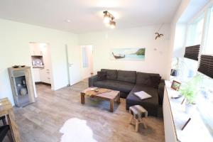 ein Wohnzimmer mit einem Sofa und einem Tisch in der Unterkunft Appartementhaus Kogge in Cuxhaven