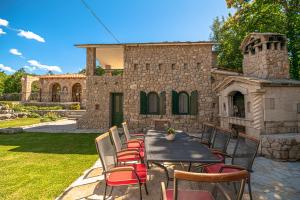 a patio with a table and chairs in front of a house at Villa Marchelina in Grubine