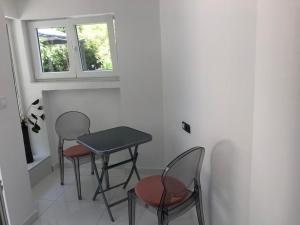 een tafel en stoelen in een kamer met een raam bij House Filomena in Rab