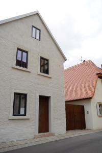 una casa bianca con due porte garage e un tetto rosso di Quartier No. 5 a Nordheim