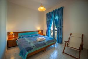 a bedroom with a bed and a chair and a window at MisterCrete Holidays House in Milatos