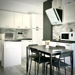 cocina con mesa de comedor negra y sillas en Residenza stadio en Turín