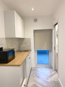 a kitchen with a counter with a microwave and a window at Seaporth Studio St Ives in St Ives +6 photos
