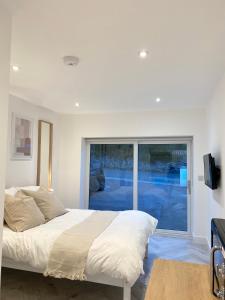 a bedroom with a bed and a large window at Seaporth Studio St Ives in St Ives
