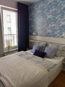 a bedroom with a bed with a blue wall at Apartament Azzurro Ustronie Morskie in Ustronie Morskie