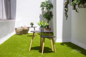 dos mesas sobre hierba en una habitación con plantas en MRZ Rentals Jerez Centro, en Jerez de la Frontera