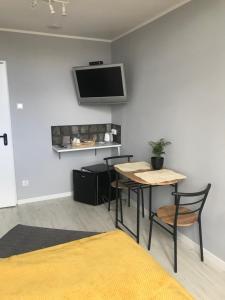a room with a table and chairs and a tv on the wall at MALTINA in Malbork