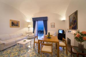 a living room with a couch and a table at La Caravella di Positano - Relais, Beach & Residences in Positano