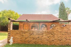 a brick house with a statue in front of it at Comfy Menlyn Maine Appartment in Pretoria