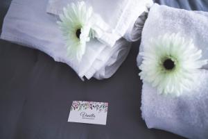 un paio di asciugamani con fiori su un letto di da Vanilla affittacamere a Bonzicco