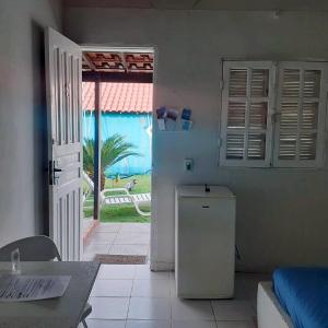 a room with a refrigerator and a door to a yard at Pousada da Praia in Itaipuaçu