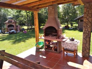 un horno de pizza al aire libre en un patio con mesa en Vacation home Zara, en Lohovo