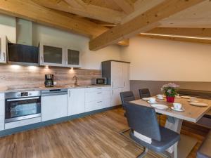 een keuken met een tafel en stoelen in een kamer bij Ferienwohnung Obersteintal in Söll