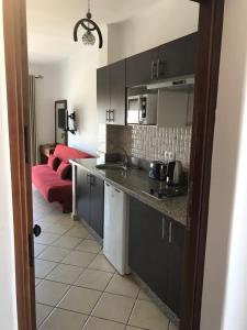 a kitchen with black cabinets and a red couch at Studio avec piscine Cabo Dream à Cabo négro in Cabo Negro