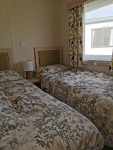 a bedroom with two beds and a window at Luxury Holiday Home in Anderby Creek in Anderby