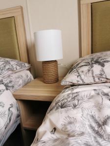 a lamp on a night stand next to a bed at Luxury Holiday Home in Anderby Creek in Anderby
