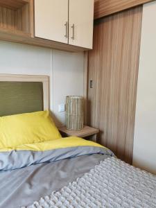a bedroom with a bed with a yellow pillow and cabinets at Luxury Holiday Home in Anderby Creek in Anderby