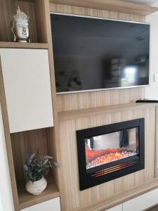 a living room with a fireplace and a tv at Luxury Holiday Home in Anderby Creek in Anderby