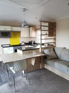 a kitchen and living room with a couch and a table at Luxury Holiday Home in Anderby Creek in Anderby