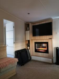 a living room with a fireplace and a flat screen tv at Luxury Holiday Home in Anderby Creek in Anderby