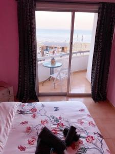 a bedroom with a bed and a view of the beach at Beach Front Apartment in Larnaka
