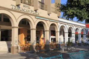a building with tables and chairs in front of it at Hotel Tehuacan Plaza in Tehuacán