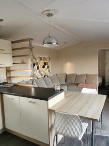 a kitchen and living room with a table and a couch at Luxury Holiday Home in Anderby Creek in Anderby