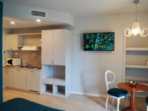 a kitchen with white cabinets and a table and a chair at Haus Bethusy in Bellagio