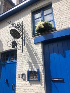a building with blue doors and a plant in a window at BRU-LAGOON Guesthouse in Bruges