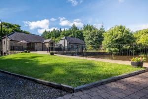 un patio con una valla y una casa en Tully Mill Cottages en Bellanaleck