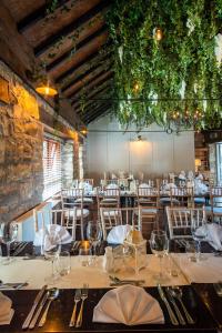 una sala da pranzo con tavoli e sedie con bicchieri da vino di Tully Mill Cottages a Bellanaleck