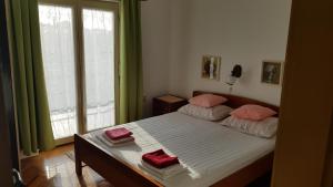 una camera da letto con un letto con cuscini rosa di Apartment Katica a Crikvenica