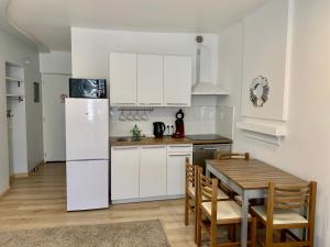 a kitchen with a table and a white refrigerator at Excellent Studio au cœur historique de Fréjus in Fréjus