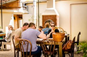 un grupo de personas sentadas en una mesa en Casa Ciortea Ana, en Sibiel