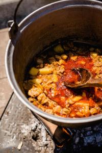 a pot of food on a stove with a spoon at Casa Ciortea Ana in Sibiel